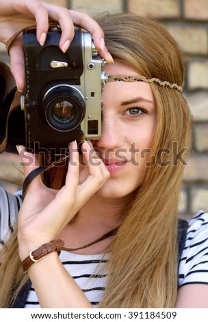 closeup portrait of beautiful young girl with retro camera, outdoors shoot