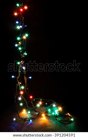 Christmas romantic lights frame on black background with copy space. Decorative garland in night space. Clear perfect beautiful decoration for intimate evening dinner. Studio close up photo. Seamless.