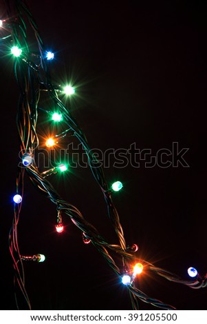 Christmas romantic lights frame on black background with copy space. Decorative garland in night space. Clear perfect beautiful decoration for intimate evening dinner. Studio close up photo. Seamless.