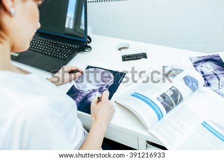Female doctor or nurse looking at radiography photo