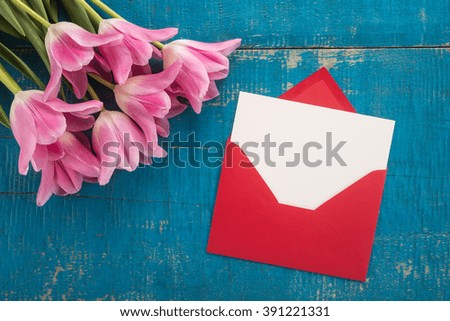 Flowers and envelope on a wooden background 