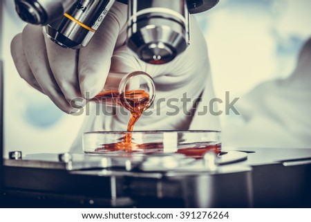 Serious clinician studying chemical element in laboratory Vintage Royalty-Free Stock Photo #391276264
