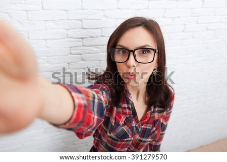 Young Beautiful Girl Taking Selfie Picture With Duck Face Lips Smart Phone Photo Camera Over White Brick Wall