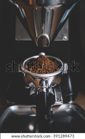 freshly ground coffee beans in a portafilter by the coffee grinder Royalty-Free Stock Photo #391289473
