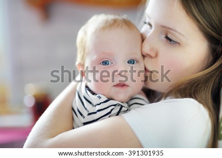 Young mother holding his sweet newborn baby