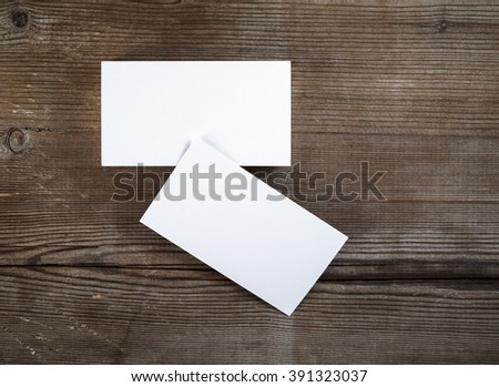 Photo of blank business cards on dark wooden background. For design presentations and portfolios.