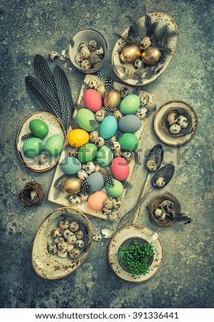Easter decoration with colored eggs and birds feather. Boho style holidays background. Vintage toned picture