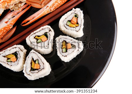 Maki Rolls and California rolls made of fresh raw Salmon, Tuna and Eel . on black dish with boiled crab . Maki Sushi and Nigiri
