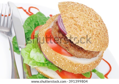 big double hamburger on ceramic plate with cutlery isolated  over white background
