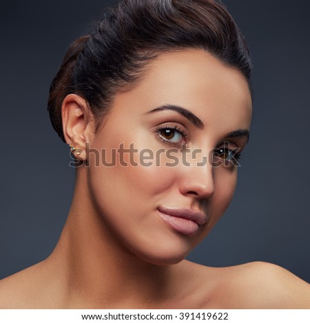Beauty face of caucasian young beautiful brunette woman with health clean skin on gradient grey background. Studio portrait. Toned
