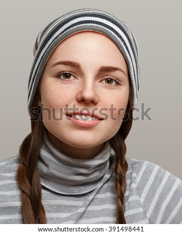 Fashion girl hipster with two long braids. Woman in stripes clothes.