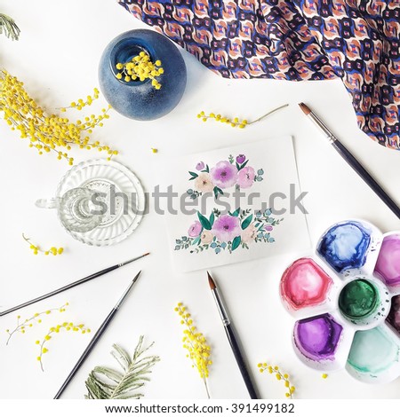Workspace. Pink and beige flowers painted with watercolor, paintbrush, yellow acacia, dress and candlestick isolated on white background. Overhead view, top view