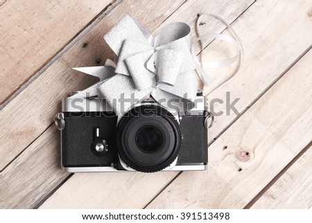 Old rangefinder vintage and retro photo camera  isolated on wood background with bow ties for gift