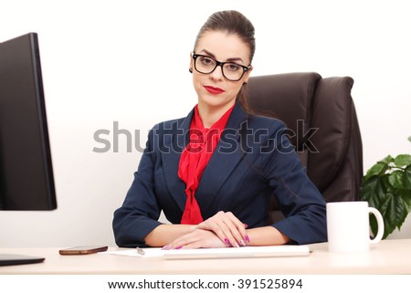 Portrait of businesswoman with laptop writes on a document at her office