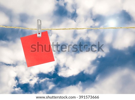 Notes paper cards in clothes pegs on rope  on sky background