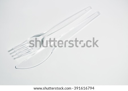 Plastic plug and knife lie a cross on a white background.