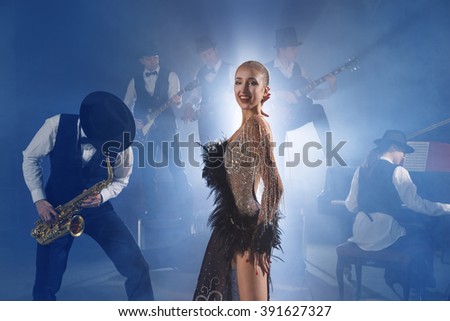 Dancer in front of the audience with a guitar sounds, piano and saxophone