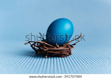 Easter eggs in nest on blue background Royalty-Free Stock Photo #391707484
