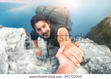 adventurers helping each other to climb the mountain Royalty-Free Stock Photo #391722010