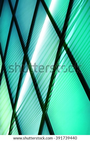 Striped structure of jalousie / louvers / blinds shadows on backlit modular glass wall / partition. Abstract architectural / interior photo in contemporary style.
