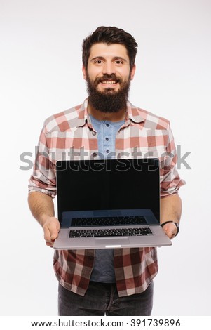 Portrait of handsome hipster bearded man with laptop. Bearded Man demonstrating laptop against white background