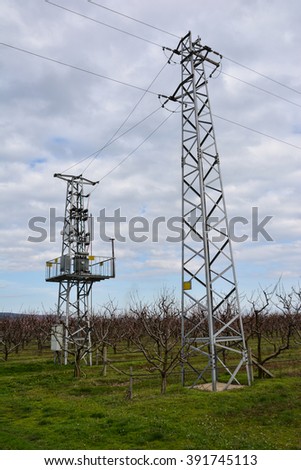 Electricity transmission pylons against cloudy sky 