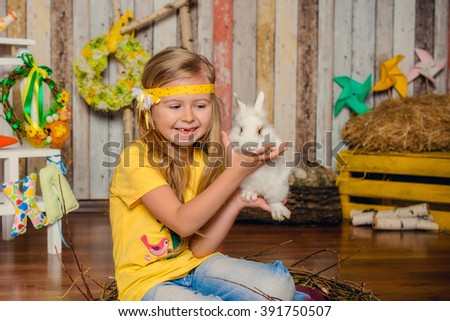 Little girl with bunny for Easter holiday in yellow smile on hands