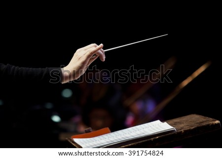 conductor's hand on a black background  Royalty-Free Stock Photo #391754824