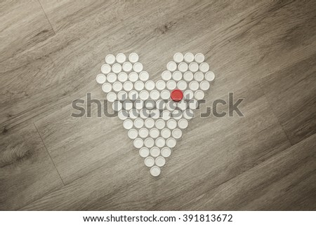 Heart shape solidary made with recycled plastic caps on a wooden floor Royalty-Free Stock Photo #391813672