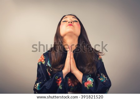 Closeup portrait young woman in kimono praying