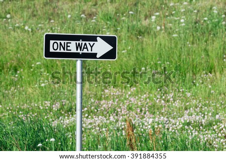 one way sign against green tree background