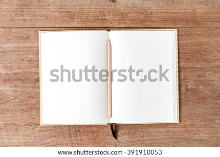 Blank open notebook with pencil on wood table,Business template mock up for adding your text