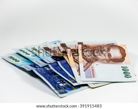 Asian currency on white background. 1000 Thai banknotes and 1000 New Taiwan Dollar banknotes.
