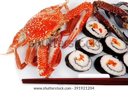 Maki Sushi : Maki Rolls and California rolls made of fresh raw Salmon, Tuna and Eel . on black dish with red and blue crabs .