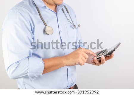 Selective Focus : Portrait of unknown male doctor holding his stethoscope, use calculator . On gray background with shadow