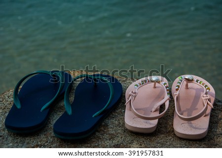 Flip flops on a sandy ocean beach.