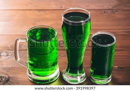 St. Patricks Day with a full glass of beer and with golden coins on the wooden desk