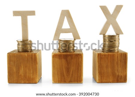 Stacked coins with wooden cubes and word TAX isolated on white