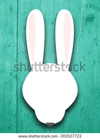 Close-up of one hanged blank rabbit silhouette frame with clip against aqua wooden boards background