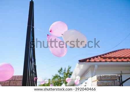 three balloons hanging on metal fence