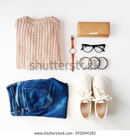 Beige pullover, blue jeans, glasses, bracelets, pink shoes, watch, brown wallet isolated on white background. Overhead view. Flat lay, top view Royalty-Free Stock Photo #392044282