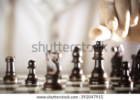 Board game, chess player hand about to play, excellence concept.