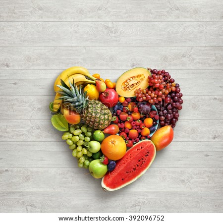 Heart symbol. Fruits diet concept. Food photography of heart made from different fruits on white wooden table. High resolution product.