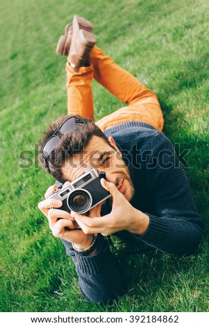 Young stylish man using vintage camera
