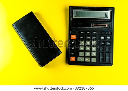 calculator and purse on a yellow background