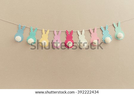 Easter Bunny Banner. Cute bunny shapes with yarn pom pom tails. Royalty-Free Stock Photo #392222434