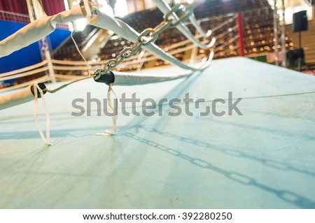 Boxing ring ropes and chains tensioned by turnbuckle anchor on blurred background
