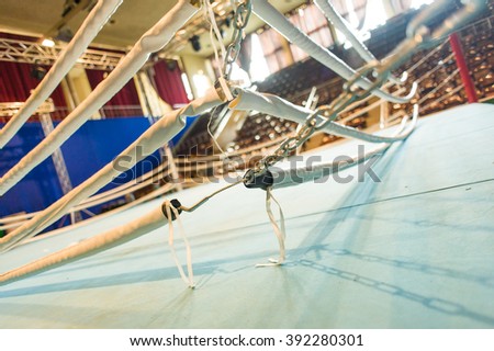 Boxing ring ropes and chains tensioned by turnbuckle anchor on blurred background