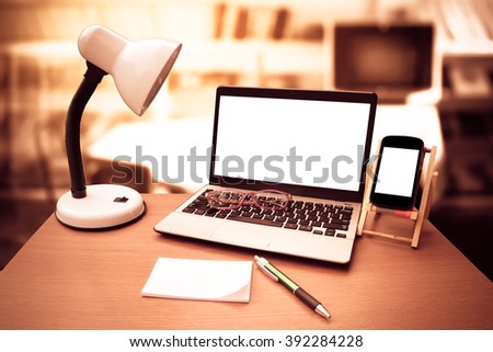 laptop on table with blur library room background