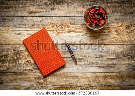 Blank notebook with pencil and  flower on vintage wooden table